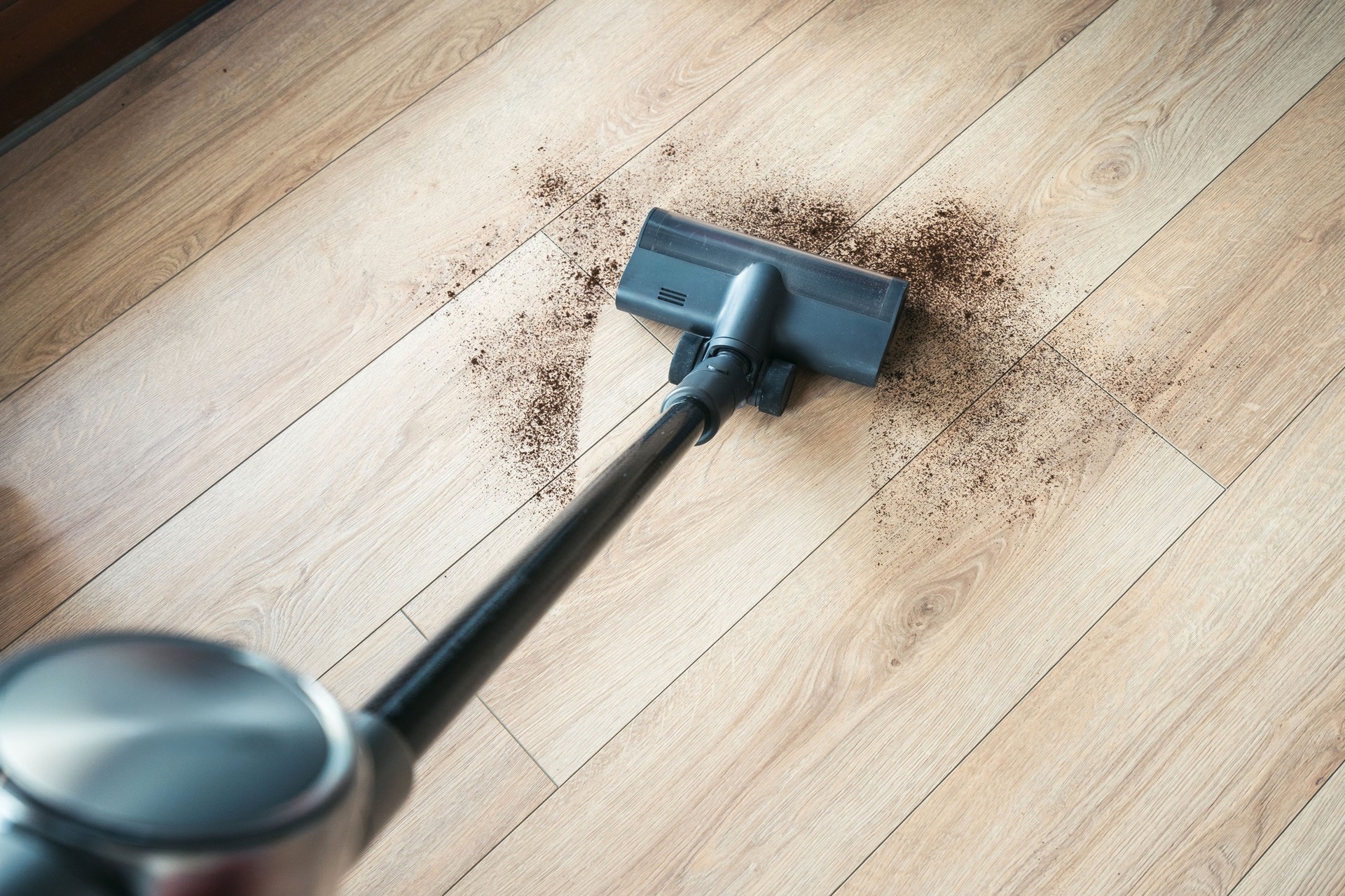 Cleaning hardwood floors with a vacuum, high angle view
